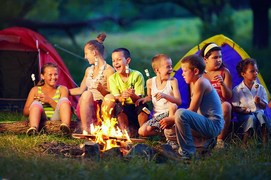 Eine Gruppe Kinder am Lagerfeuer - Schließe-neue-Freundschaften-Tag